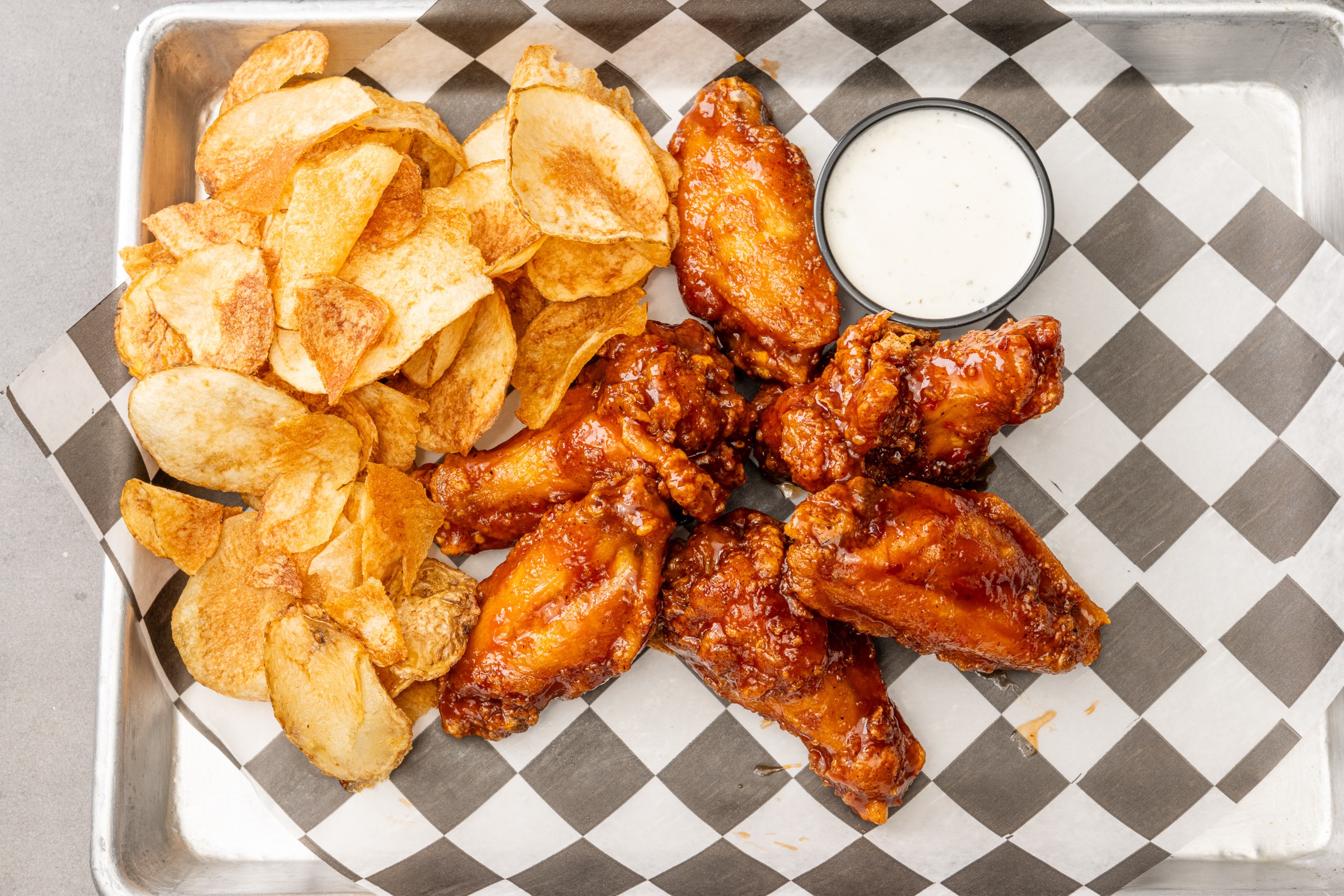 Top view chicken wings with potato chips and sauce